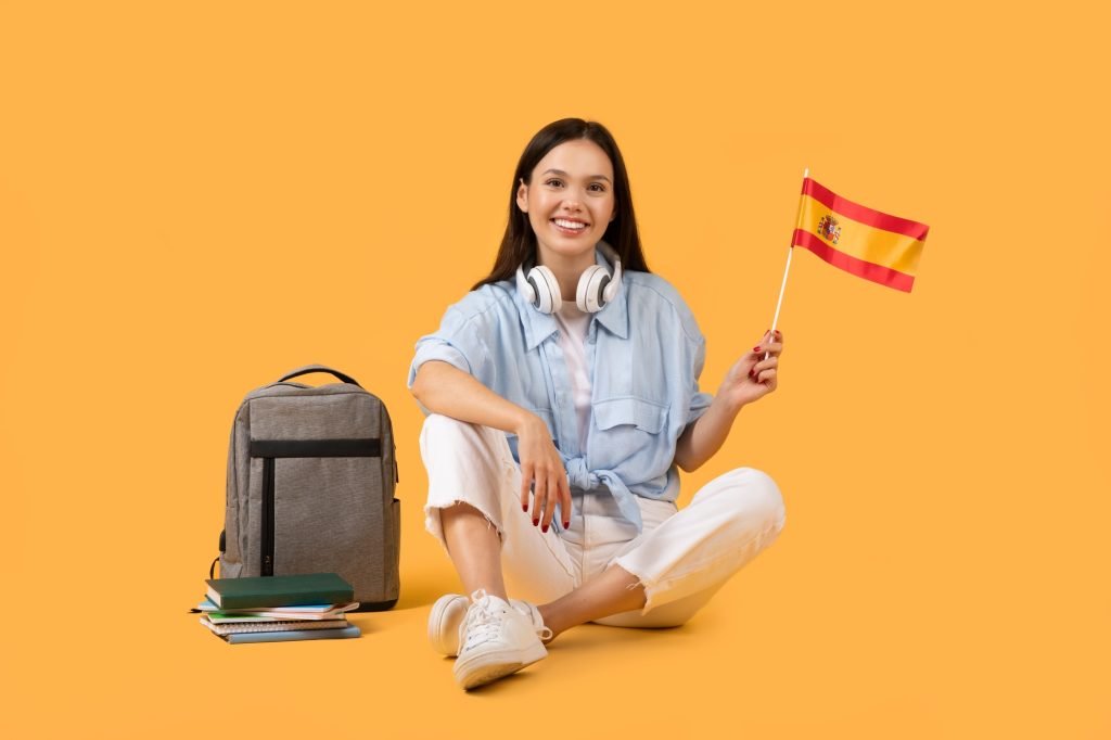Happy woman with Spanish flag on yellow background