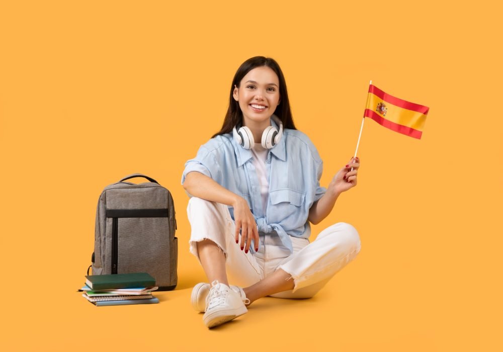 Happy woman with Spanish flag on yellow background